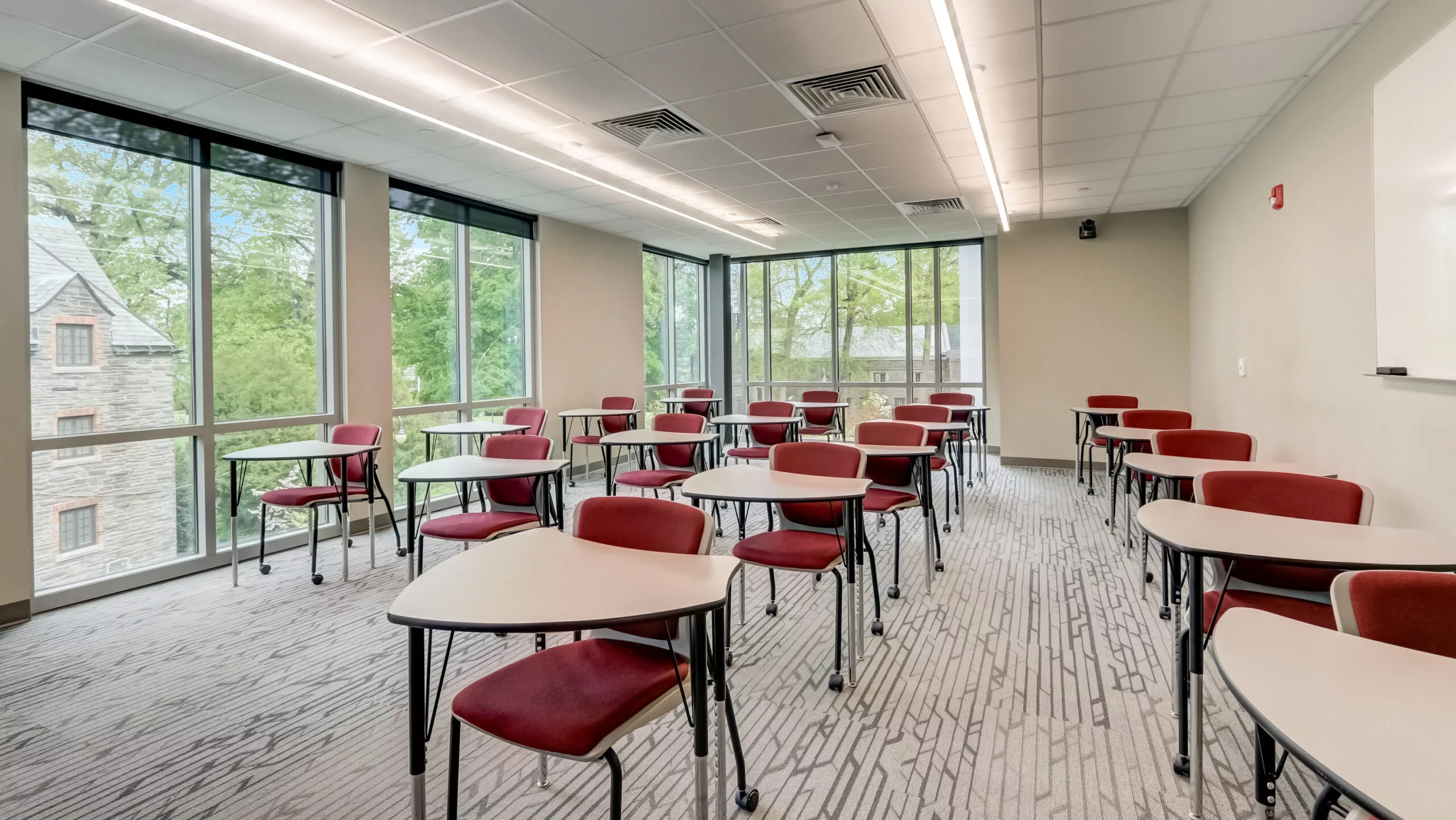 Classroom in the Sharon Latchtaw Hirsh Community Center with desks and campus views through floor-to-ceiling windows are part of why Rosemont College is Forbes rated best online college, and a best mainline college.