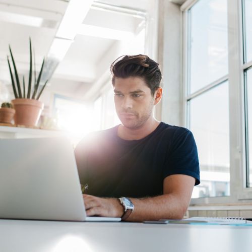 Man concentrating on a laptop to represent how the Rosemont College Graduate Post Baccalaureate Certificates are part of why Rosemont College is a Forbes rated best online college, and a best mainline college.