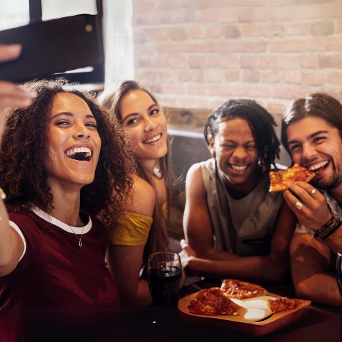African American woman smiling and about to drink a cup of coffee to represent how  the local area is part of why Rosemont College is Forbes rated best online college, and a best Main Line college.