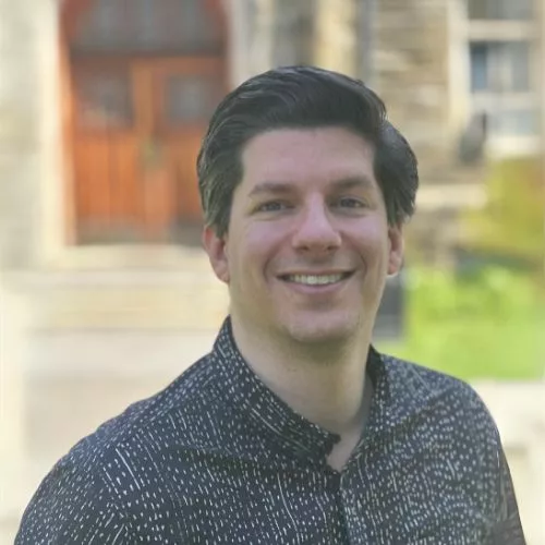 A smiling Sean Austin who is Rosemont College's Vice President of Finance & Administration is in front of Good Counsel representing how the controller is part of why Rosemont College is a Forbes rated best online college, and a best Main Line college.