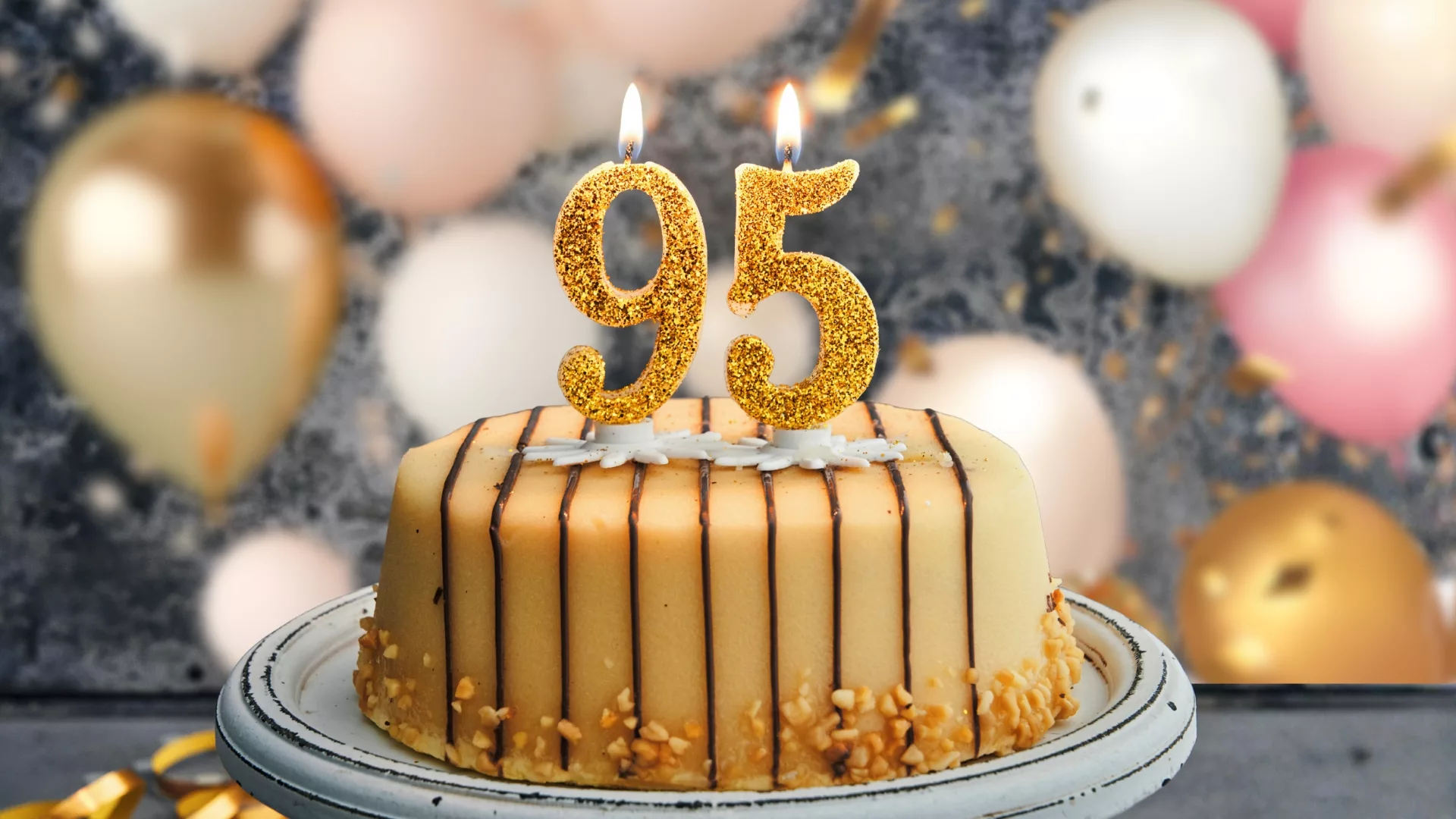 Close up of a cake with candles with the numbers 95 to represent how alumna Ms. Pat Carbine is part of why Rosemont College is a Forbes rated best online college, and a best Main Line college.