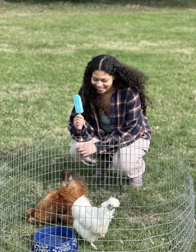 A student visiting the petting zoo on Connelly Green for Spring Festival 2025 to represent how Student Engagement events are part of why Rosemont College is a Forbes rated best online college, and a best Main Line college.