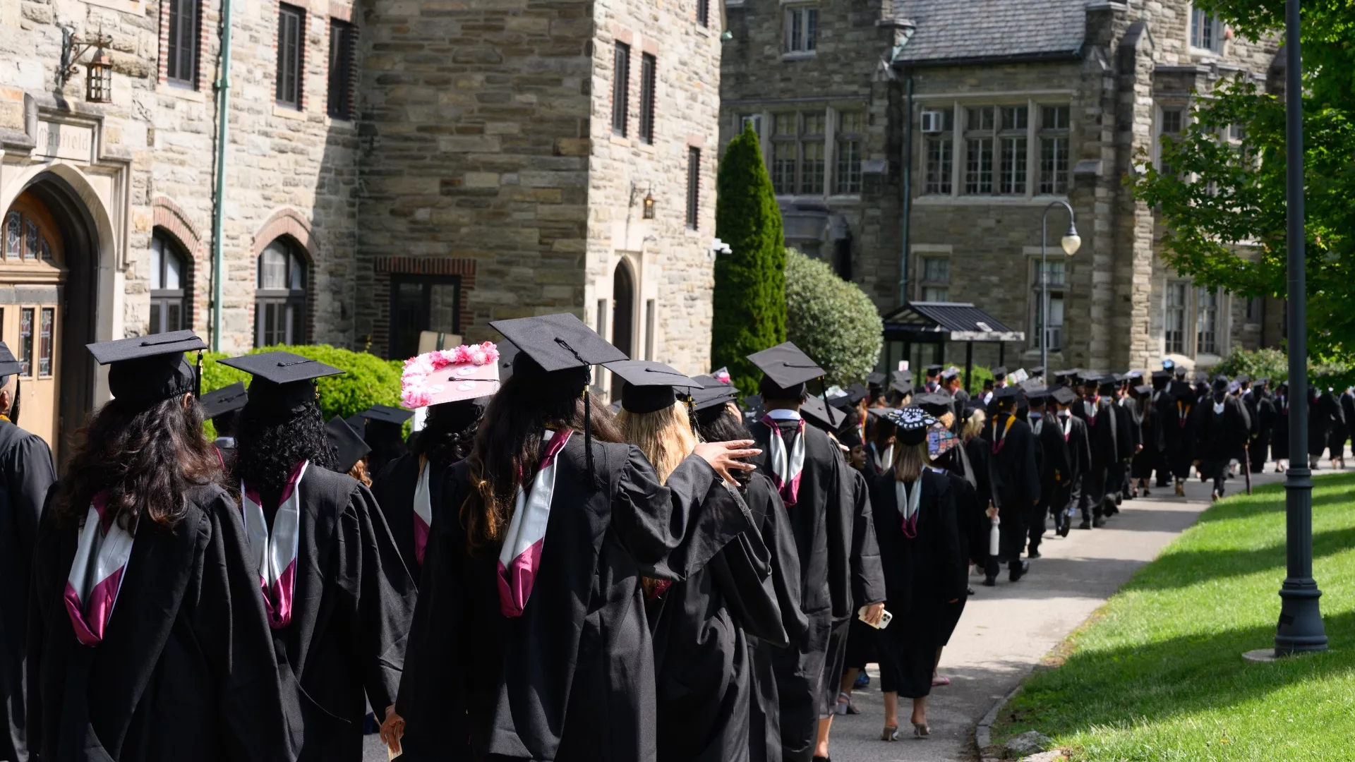 A procession of 2026 graduates approaching the 103rd Commencement Ceremony to represent how graduation is a part of why Rosemont College is a Forbes rated best online college, and a best Main Line college.