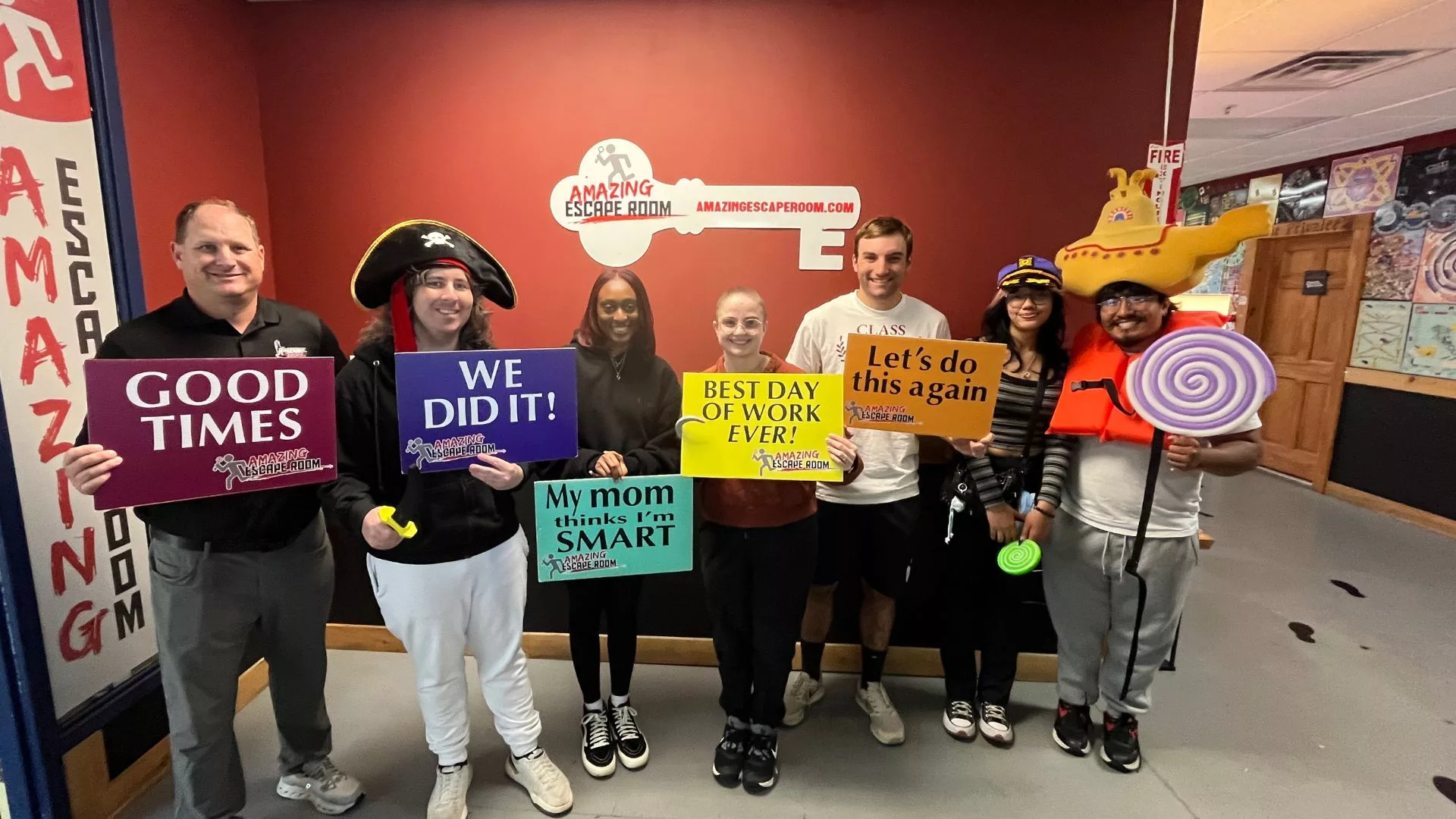 A diverse group of Rosemont College seniors hold up successful sayings and funny signs after a successful escape room effort is a part of why Rosemont College is a Forbes rated best online college, and a best Main Line college.