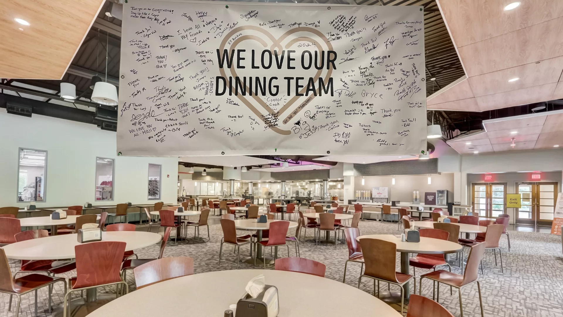 Rosemont College - Cardinal Dining Hall Cardinal dining hall with a signed banner that reads We Love Our Dining Staff to represent how Student Life is part of why Rosemont College is a Forbes rated best online college, and a best Main Line college.