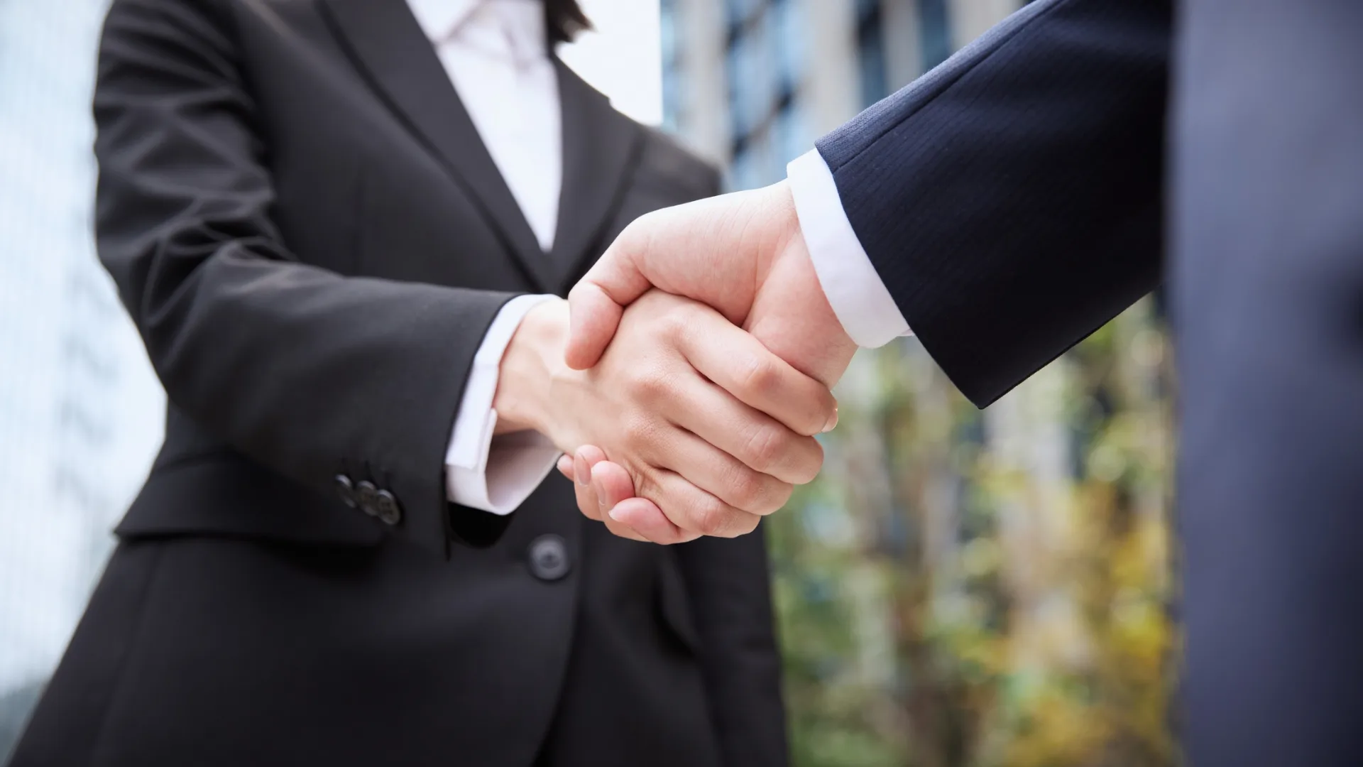 Two people dressed in business suits shaking hands is part of why Rosemont College is a Forbes rated best online college, and a best Main Line college.