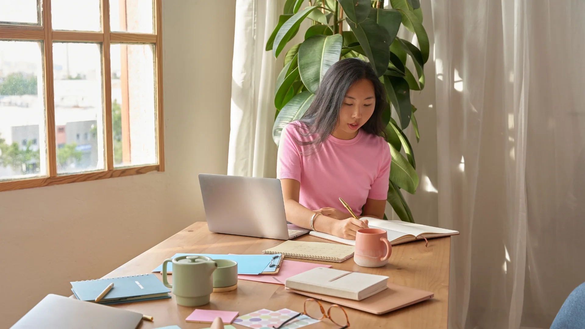 A woman working at a table to represent how internships and experiential learning are part of why Rosemont College is a Forbes rated best online college, and a best Main Line college.