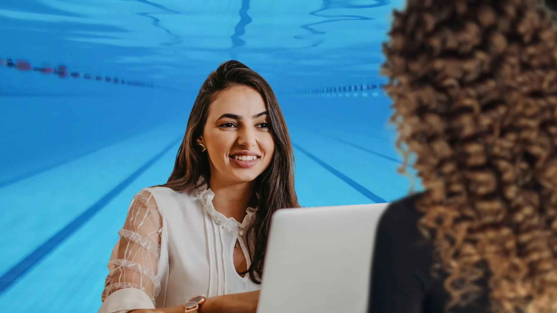 A sports marketing meeting overlaid on an image of an underwater pool to represent how internship and experiential learning opportunities are part of why Rosemont College is a Forbes rated best online college, and a best Main Line college.